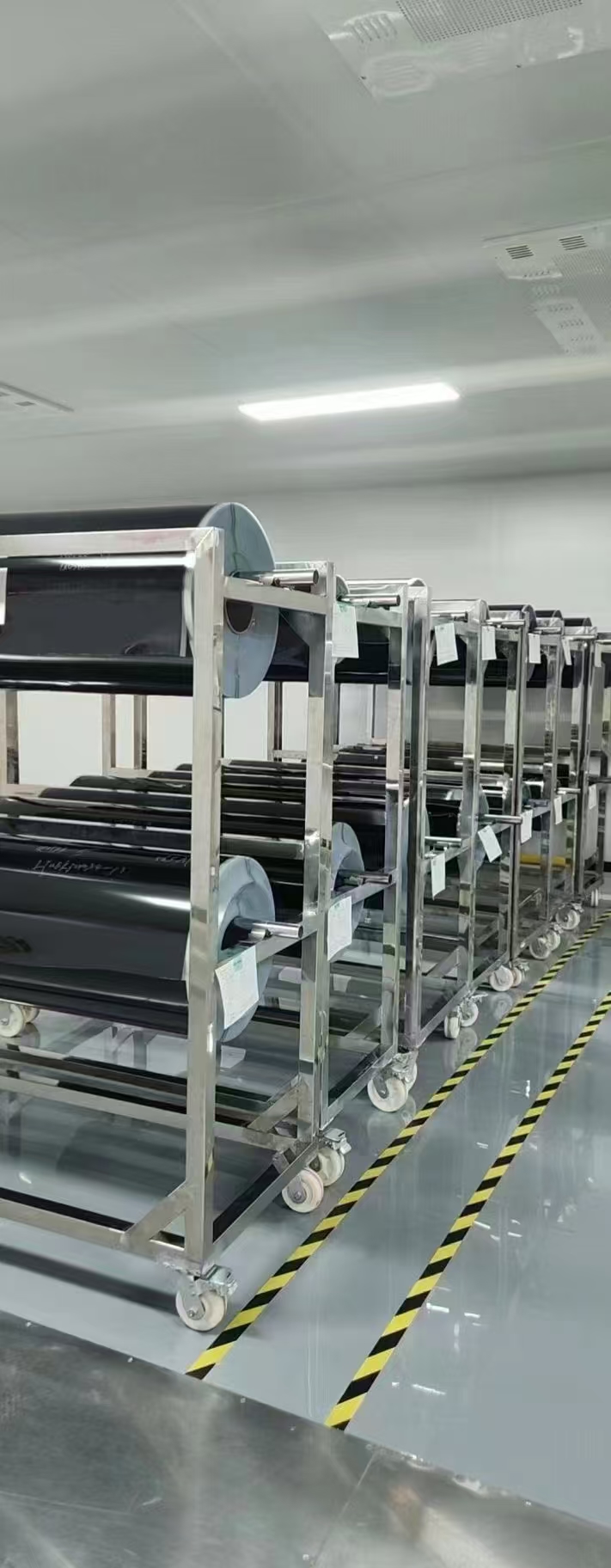 Stocked black automotive window film rolls on mobile racks